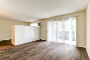 the spacious living room and dining room of an apartment