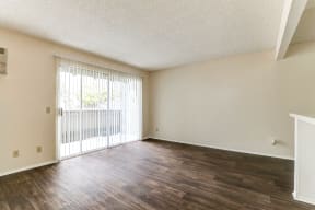 spacious living room with hard wood floor and sliding glass door