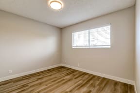 an empty room with wood floors and a window