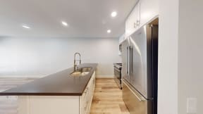 a kitchen with white cabinets and a stainless steel refrigerator at Charter Oaks Apartments, California, 91360