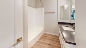 a bathroom with a sink and a bath tub and a mirror at Charter Oaks Apartments, California, 91360