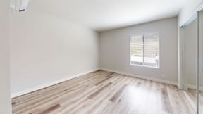 an empty room with wood flooring and a window at Charter Oaks Apartments, California, 91360