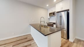 a kitchen with a large island and a stainless steel refrigerator at Charter Oaks Apartments, California, 91360