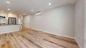 an empty living room and kitchen with wood flooring at Charter Oaks Apartments, California, 91360