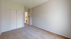 a bedroom with a white door and a carpeted floor at Charter Oaks Apartments, California, 91360
