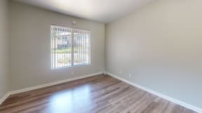 an empty living room with wood floors and a window at Charter Oaks Apartments, California, 91360