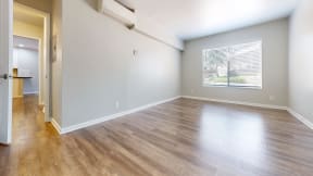 an empty living room with wood floors and a window at Charter Oaks Apartments, California, 91360