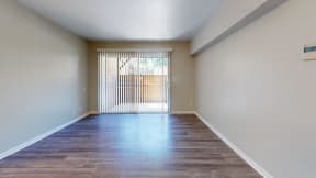 the spacious living room of an empty house with a large window at Charter Oaks Apartments, California, 91360
