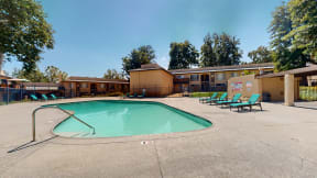 our resort style swimming pool is next to our hotel buildings and trees at Charter Oaks Apartments, California, 91360