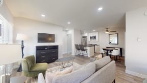 a living room with a couch and a table with chairs and a television at Charter Oaks Apartments, California, 91360 at Charter Oaks Apartments, California