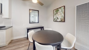 a dining room with a table and chairs and a kitchen at Charter Oaks Apartments, California