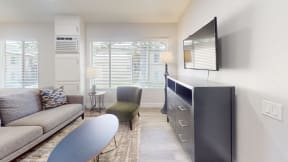 a living room with a couch and a tv and a table at Charter Oaks Apartments, California
