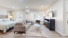 a living room with a couch and a chair and a bed at Charter Oaks Apartments, California