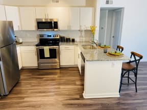 Apartments for Rent Denver CO - Allure Apartments Kitchen With Stainless Steel Appliances, Hardwood Floors, Granite Countertops, And Sleek White Cabinetry