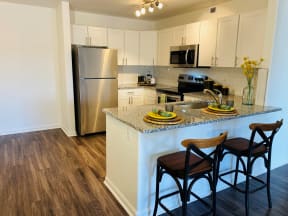 Apartments For Rent In Windsor - Interior View Of The Kitchen Which Features Stainless Steel Appliances, Granite Countertops, Contemporary White Cabinets With Matching Backsplash, Modern Ceiling Light