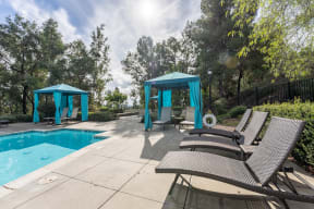 a swimming pool with chairs and umbrellas at Alta Vista, Escondido, California