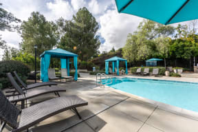 a swimming pool with chairs and umbrellas at Alta Vista, Escondido