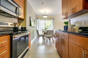 Mountain View Apartments - Americana - Kitchen with Light Wood Cabinets, Granite Style Countertops and Stainless Steel Appliances