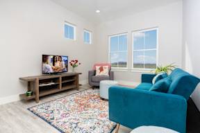 living room with blue furniture and a tv at Mihir Taylor, Taylor, Texas