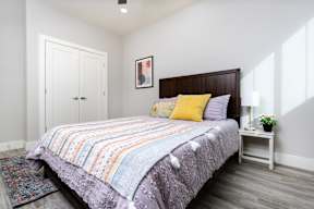 model bedroom with white walls and a bed with colorful pillows at Mihir Taylor, Taylor, TX
