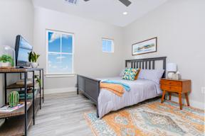 model bedroom with a bed and a desk with a tv at Mihir Taylor, Texas 76574