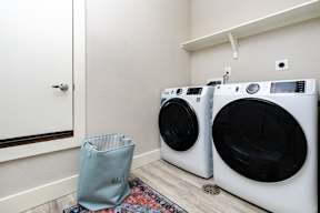 a washer and dryer in a laundry room with a mirror and a door at Mihir Taylor, Taylor, Texas