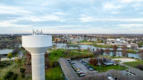 an aerial view of a water tower overlooking a city with a river at Mihir Taylor, Taylor, 76574