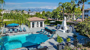 A pool area with a fountain and lounge chairs at Missions at Chino Hills Apartments, Chino Hills, CA