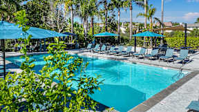 A large swimming pool surrounded by lounge chairs and umbrellas at Missions at Chino Hills Apartments, Chino Hills, 91709