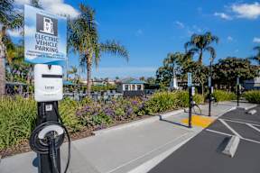 A sign for electric vehicle parking is displayed on a pole at Missions at Chino Hills Apartments, Chino Hills