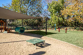 A playground with a green slide and a green table at Missions at Chino Hills Apartments, Chino Hills, California