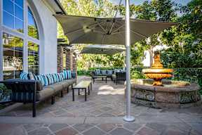 A patio with a fountain and a bench under a canopy at Missions at Chino Hills Apartments, Chino Hills