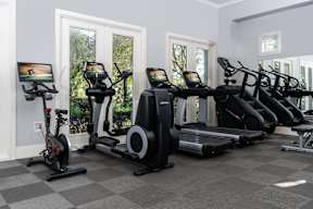 A row of exercise equipment is lined up in a room at Missions at Chino Hills Apartments, Chino Hills, 91709
