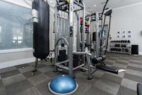 A gym with a punching bag, weights, and exercise equipment at Missions at Chino Hills Apartments, Chino Hills
