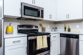Three Bedroom Apartments in Chino Hills, CA - Missions at Chino Hills - Kitchen featuring Stainless Steel Appliances, White Cabinetry, Ample Counterspace