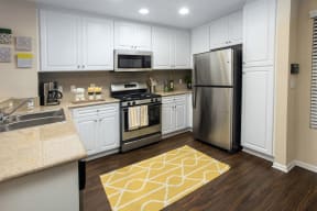 Apartments Rancho Bernardo, San Diego-The Reserve at 4S Ranch-Kitchen with Stainless Steel Appliances, Recessed Lighting, and Hardwood Flooring