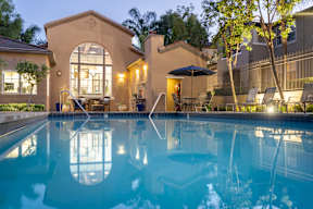 A swimming pool in a backyard with a patio and a tree. at Sonoma at Mapleton Apartments, West Murrieta, 92563