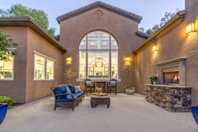 A patio with a stone fireplace and a couch. at Sonoma at Mapleton Apartments, West Murrieta, CA 92563