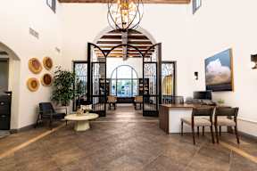 A large room with a chandelier and a long table with chairs. at Sonoma at Mapleton Apartments, California