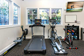 A home gym with a treadmill, exercise bike, and other equipment. at Sonoma at Mapleton Apartments, California, 92563