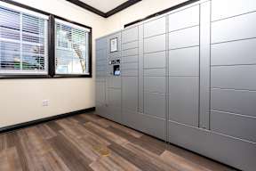 A room with a wooden floor and a wall of metal lockers. at Sonoma at Mapleton Apartments, West Murrieta, CA