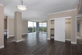 Palo Alto, California Apartments for Rent - Tan Plaza - Spacious Open-Concept Living Area with Wood-Style Flooring, Floor-to-Ceiling Windows, Panoramic Views, Hanging Light Fixtures, Balcony Access, a