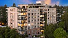 A large, modern apartment building with balconies and multiple stories.
