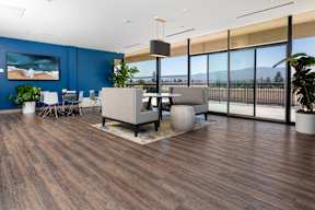 A modern office space with a wooden floor and a large window overlooking the beach.