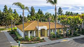 A building with a yellow sign that says "Community Center" is surrounded by trees.