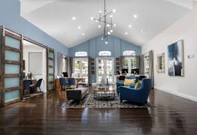 A living room with a blue couch and a wooden floor.