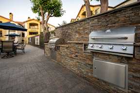 A stone wall with a built in BBQ grill.