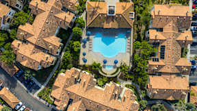 A bird's eye view of a residential area with a swimming pool.