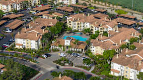 A large apartment complex with a pool in the middle.