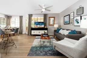 A living room with a grey couch, a wooden coffee table, and a white chair.